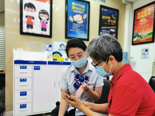 建行成都第六支行，大堂經(jīng)理為客戶介紹手機(jī)銀行“大字”模式